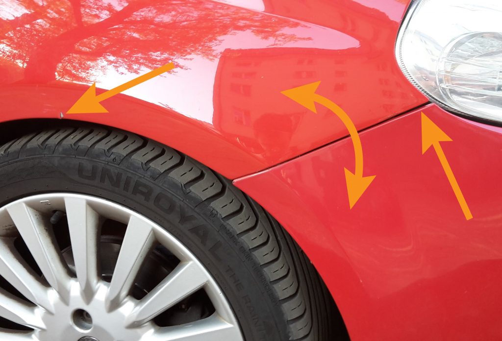 Paint shortcomings marked: colour mismatch between the fender and the bumper, paint chip on the fender and uneven panel gap.